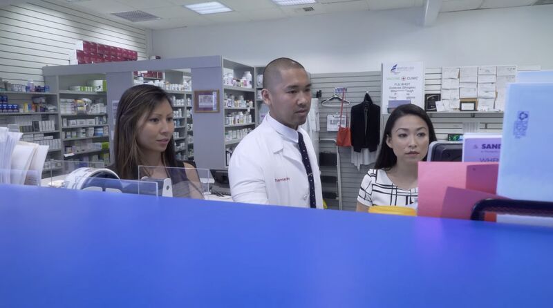 Gerard Rivera discusses patient financial barriers with two women in a pharmacy setting.